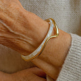 Pulseira aberta elegante com esmalte branco e dourado